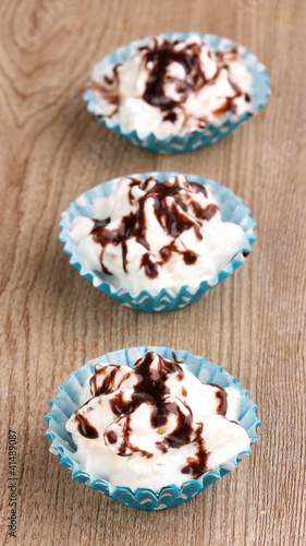 Creamy cupcakes on wooden background