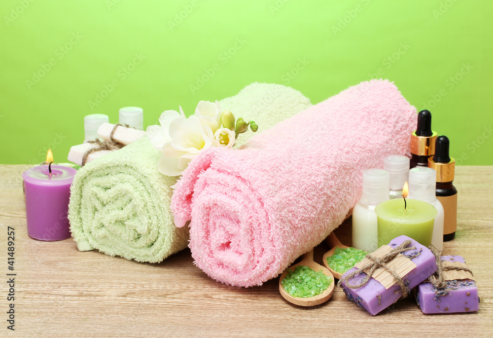 Spa setting on wooden table on green background Spa setting on wooden table on green background