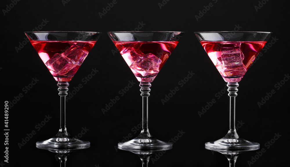 Red cocktail in martini glasses isolated on black