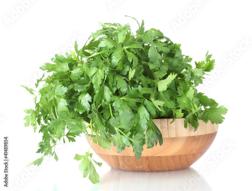 Parsley in a wooden bowl isolated on white