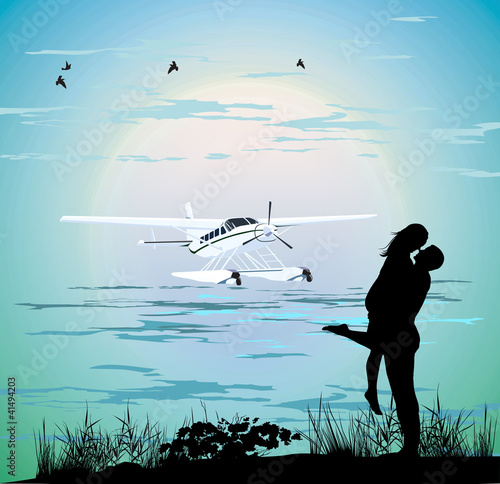couple standing on the beach near the airplane