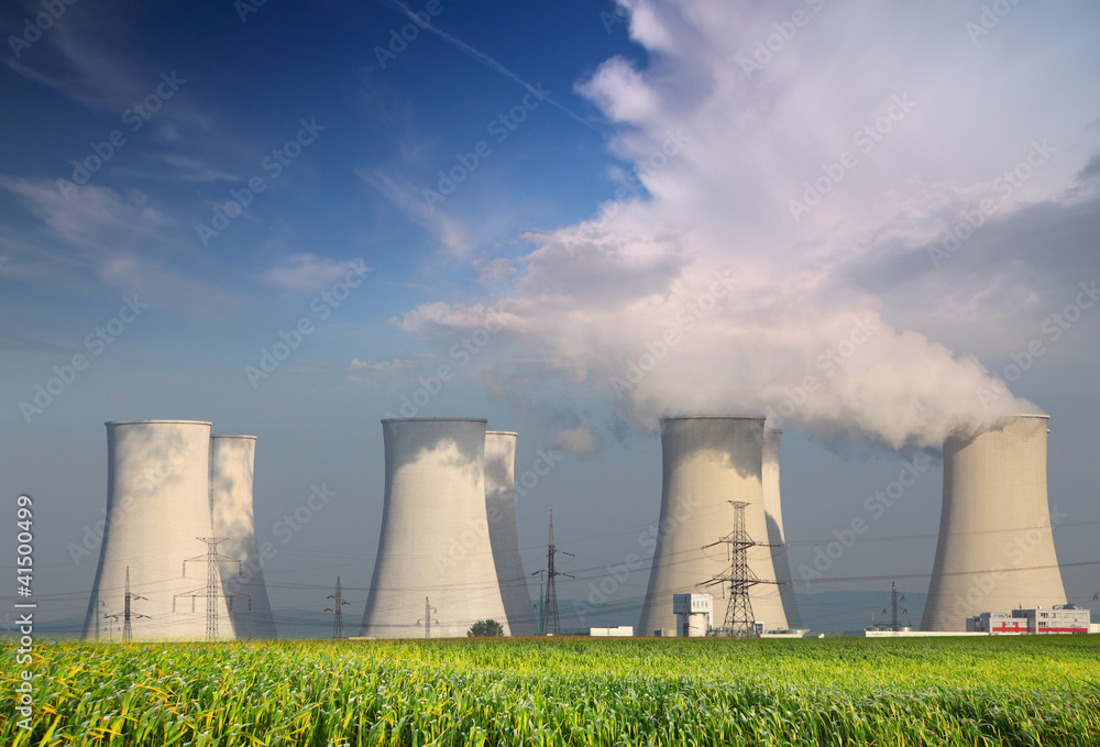 Nuclear power plant with summer field and big blue clouds.