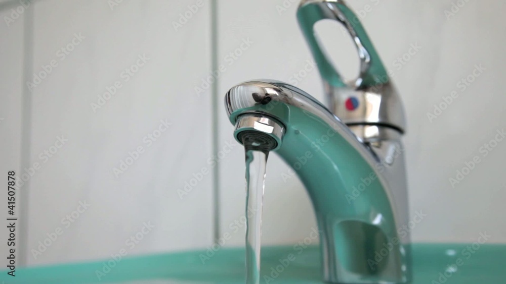Fließender Wasserhahn in einem Badezimmer im Hotel Fließender Wasserhahn in einem Badezimmer im Hotel