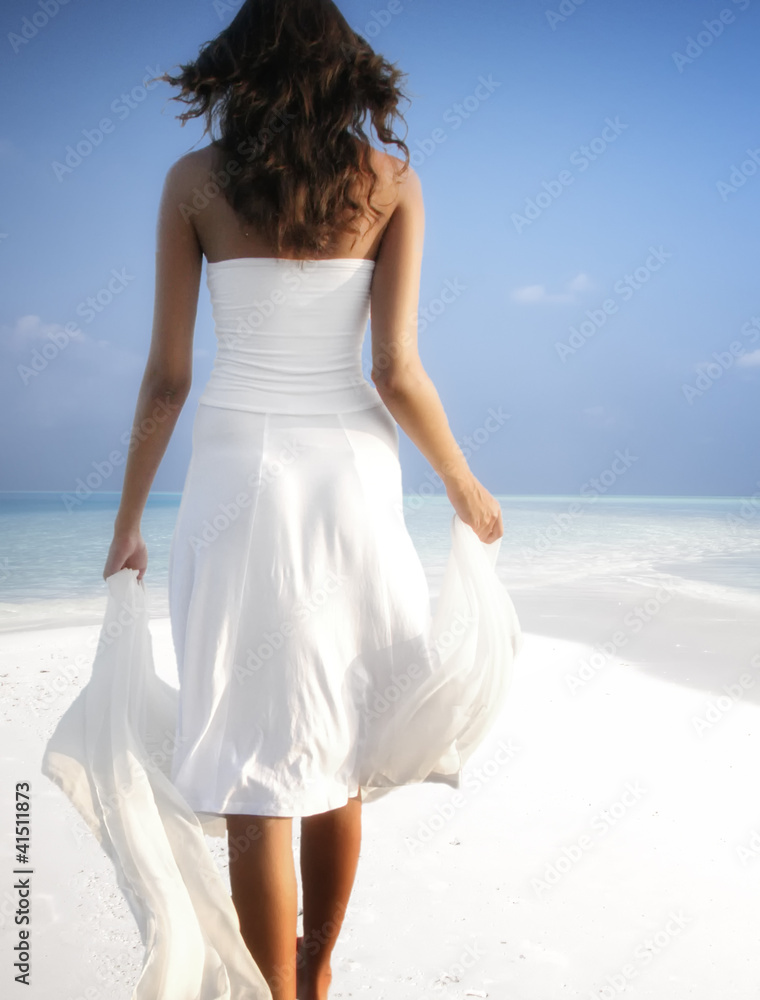 Girl walking on a white sandy beach on the Maldives (Malediven) Girl walking on a white sandy beach on the Maldives (Malediven)