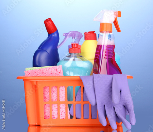 Basket with cleaning items on blue background