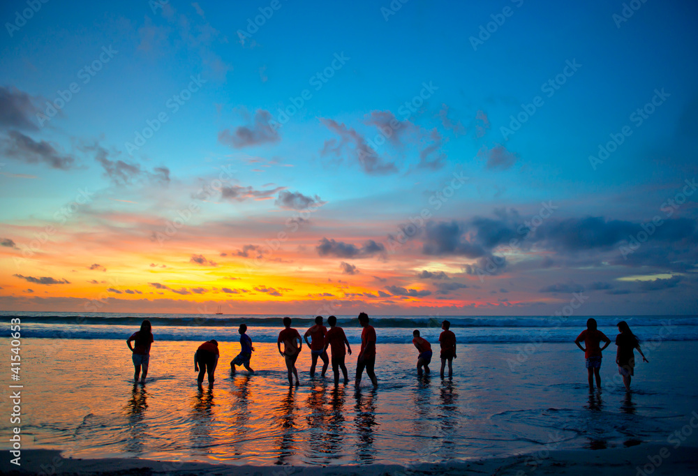 young people at sunset beach in Kuta, Bali