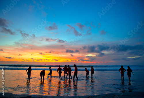 young people at sunset beach in Kuta, Bali