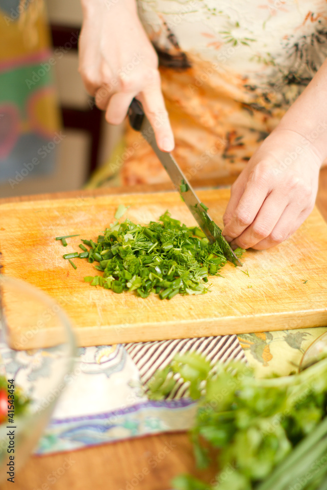 Woman's hands cutting food.Focus on green vegetables Woman's hands cutting food.Focus on green vegetables