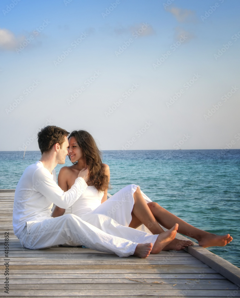 Beautiful love couple on a jetty by the sea (Maldives)