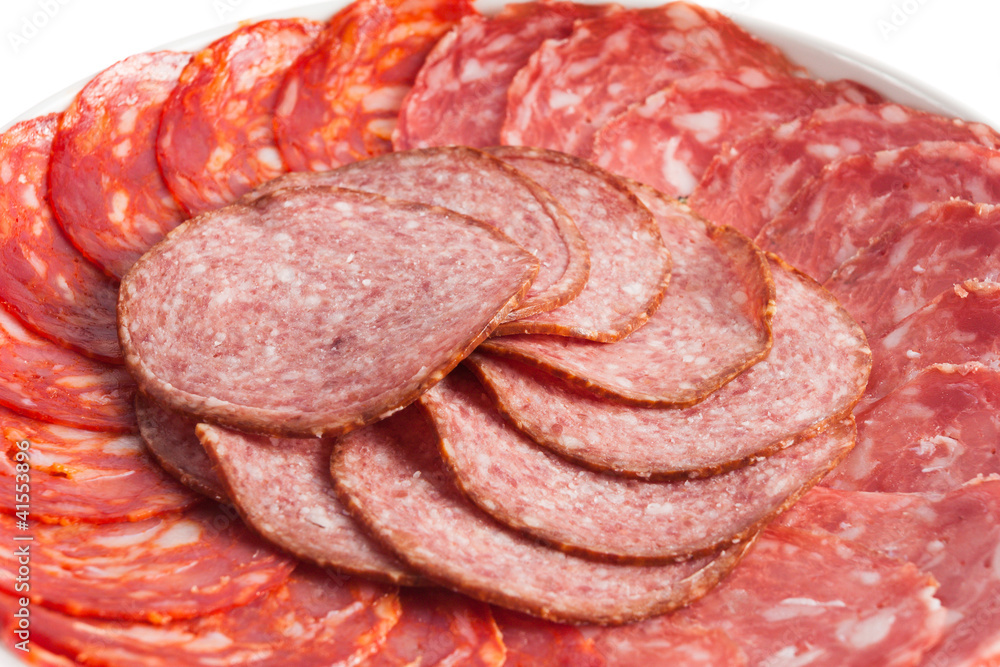 Chorizo, salchichon, salami sausages on a white plate Chorizo, salchichon, salami sausages on a white plate