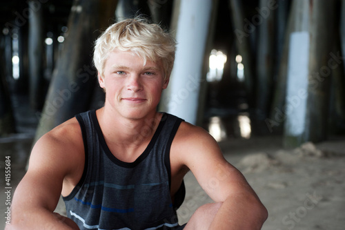 portrait of a teenage surfer boy at the beach