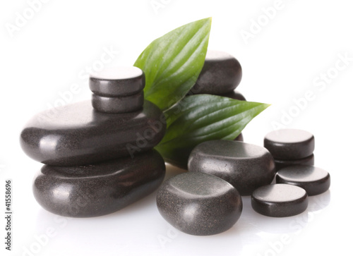 Spa stones and green leaves isolated on white