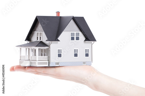 Hand holding house architectural model, isolated