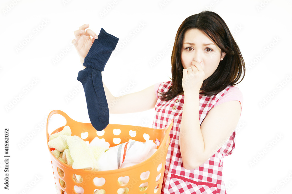 靴下を持ち鼻をつまむ女性