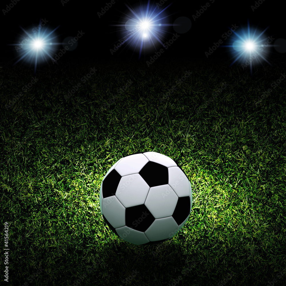 Fototapeta premium Soccer ball on grass against black background