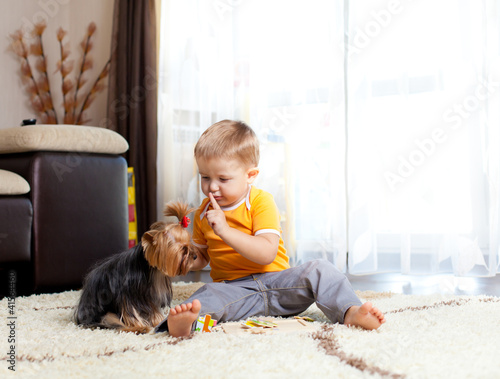 Boy with dog in living room photo