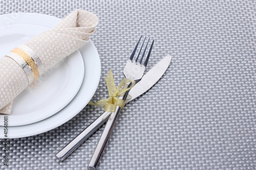 White empty plates with fork and knife tied with a ribbon