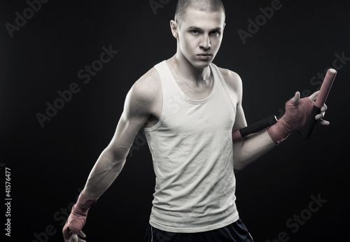 Young man posing with nunchaku photo