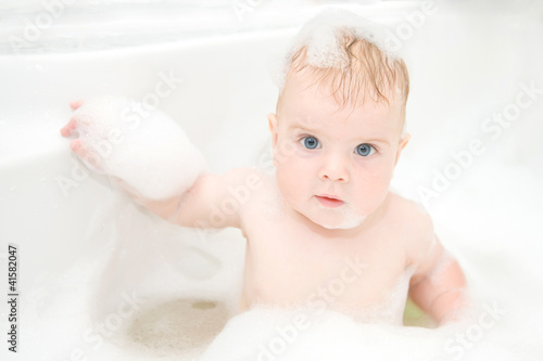 Child washing in bathroom in foam.