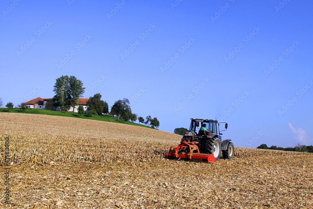 Obraz premium Landwirt mit Traktor auf Feld