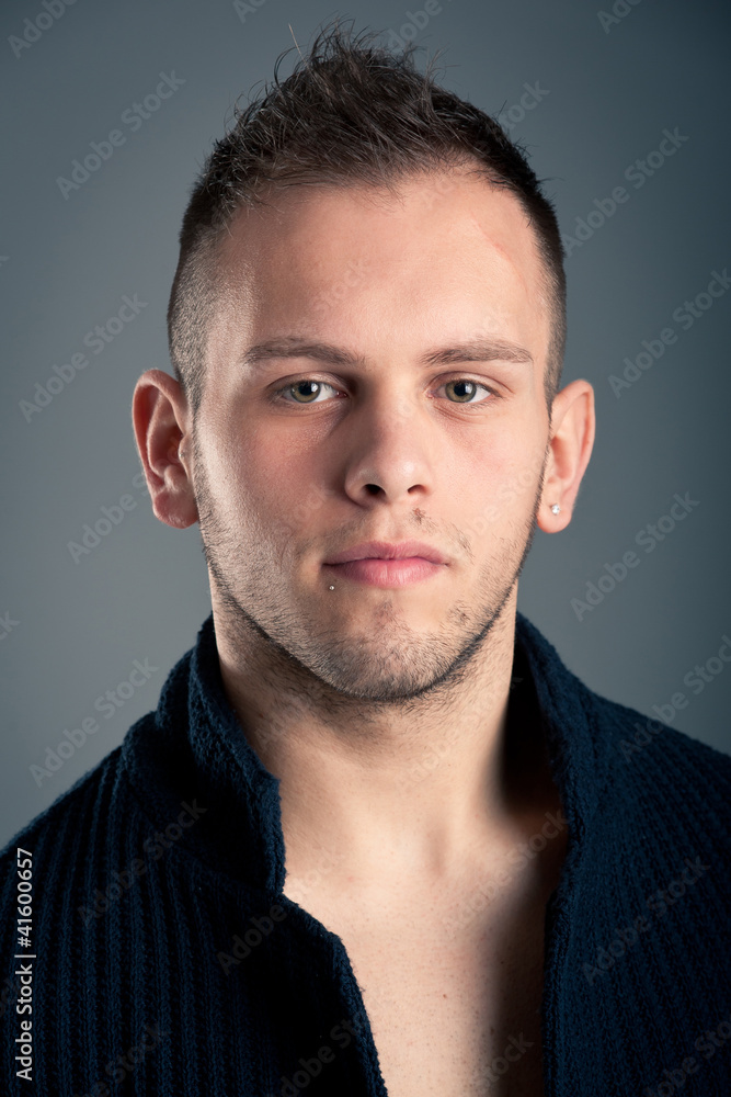 Fototapeta premium Young boy close up portrait against grey background.
