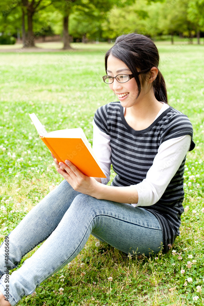 asian woman reading a book in the park asian woman reading a book in the park