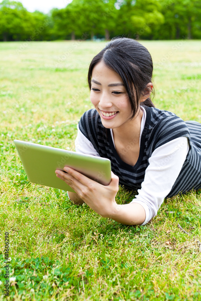 attractive asian woman using tablet computer in the park attractive asian woman using tablet computer in the park