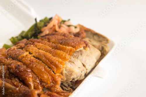 Honey roasted duck in foam box closeup