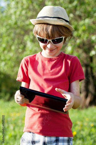 Joyful boy plays in the Tablet PC photo