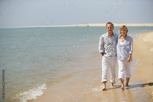 Middle-aged couple strolling along the shore