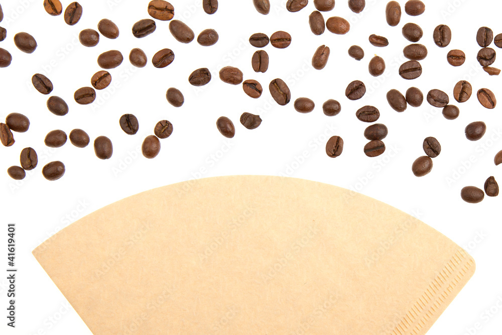 Obraz premium Coffee beans on a coffee filter (white background)
