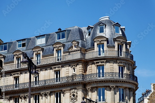 Fotografie Immeuble de pierre avec toit arrondi et balcons.