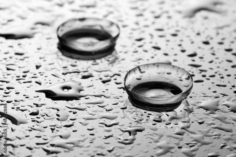 contact lens with drops on grey background contact lens with drops on grey background