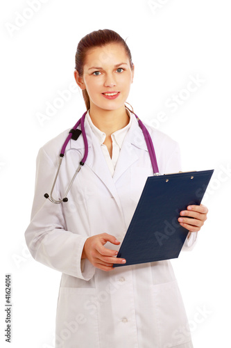 Smiling young doctor in white coat standing