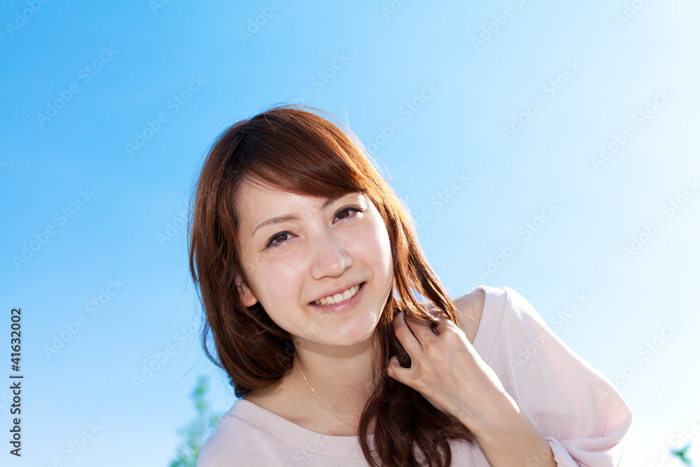 Beautiful young woman outdoors over blue sky. Portrait of asian Beautiful young woman outdoors over blue sky. Portrait of asian