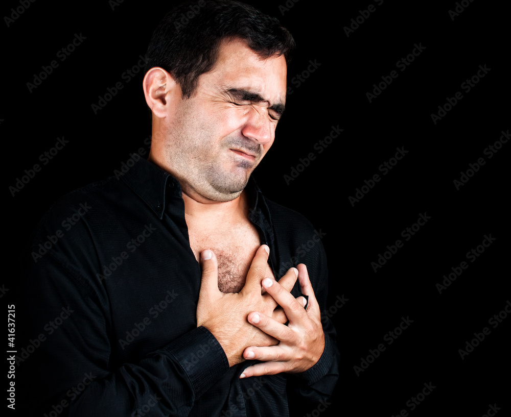 Young man having a heart attack isolated on black Young man having a heart attack isolated on black