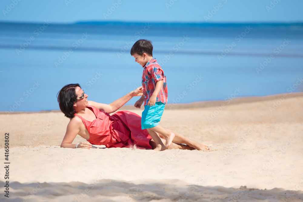 Mother and her little son playing on the beach Mother and her little son playing on the beach