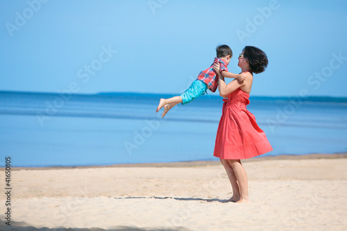 Mother and her little son playing on the beach