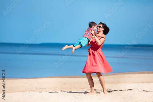 Mother and her little son playing on the beach