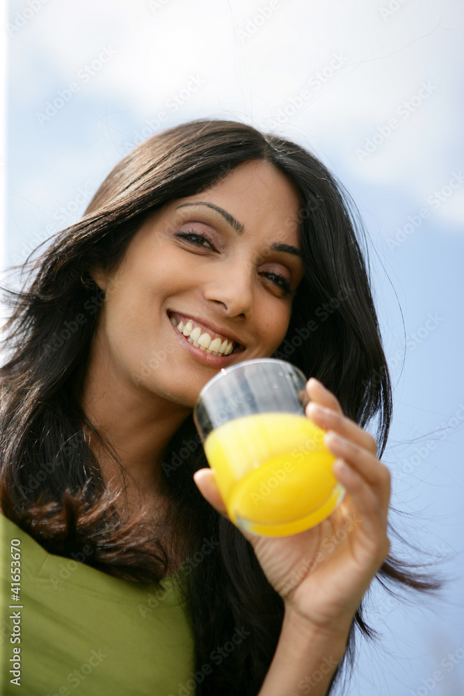 Smiling woman drinking a glass of orange juice Smiling woman drinking a glass of orange juice