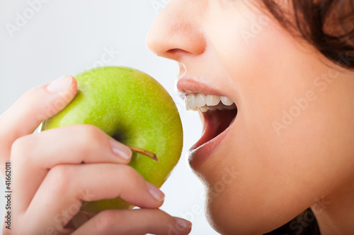 Junge Frau beißt in einen Apfel photo
