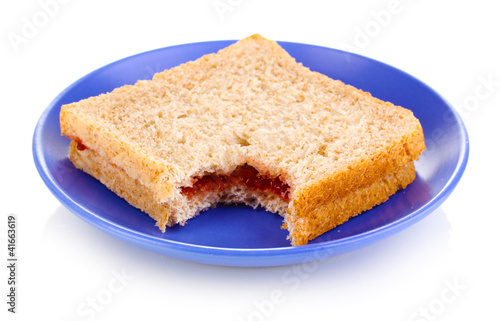 Bitten sandwich with jam on plate isolated on white