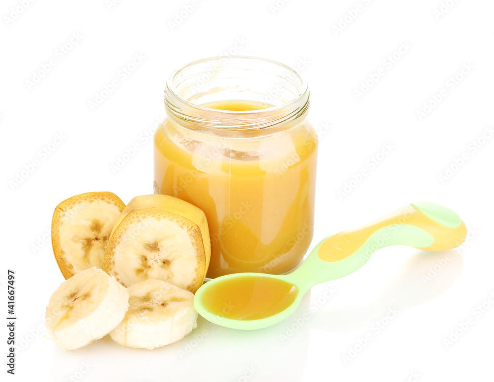 Jar of baby puree with banana and spoon isolated on white