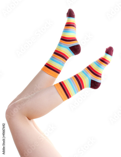 female legs in colorful striped socks isolated on white