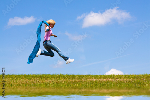 Woman jumps on the meadow