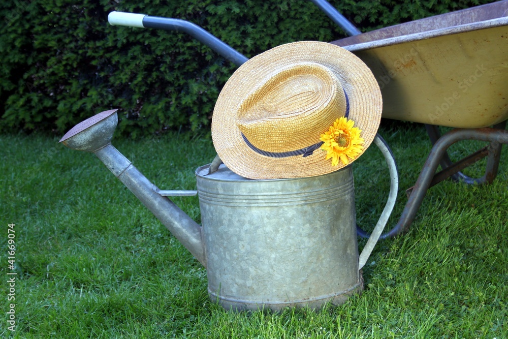 Garten Gießkanne alt mit Strohhut und Karre Garten Gießkanne alt mit Strohhut und Karre