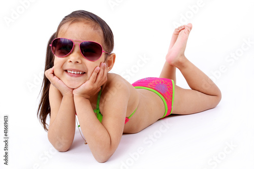 enfant allongée  en maillot de bain et lunette de soleil photo