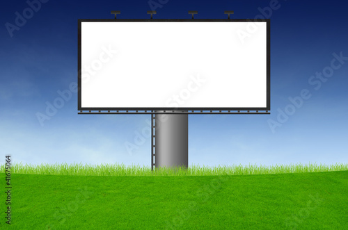 Blank billboard on green field and the blue sky in background