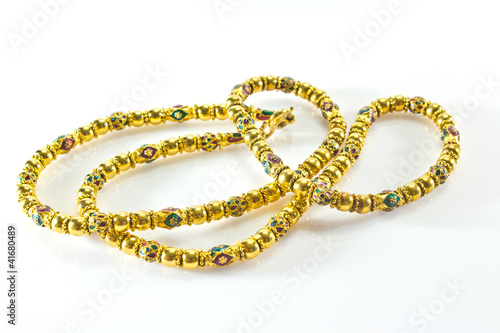 long gold necklace on a white background