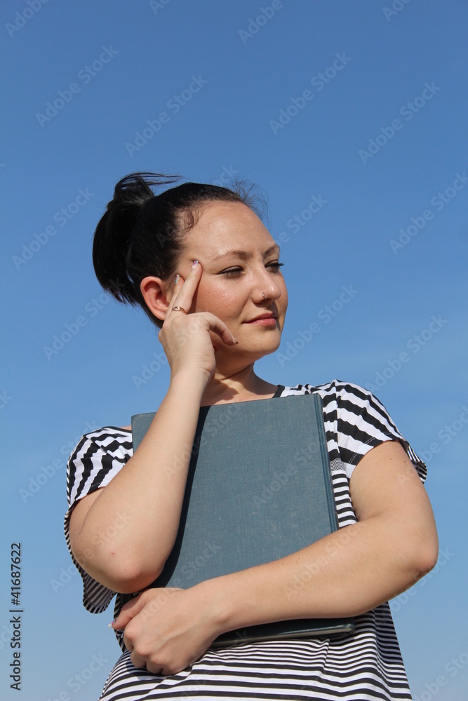 Brunette young woman holding book and thinking Brunette young woman holding book and thinking